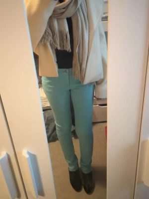 Mintgröna skinny jeans från FBsisters - Säljer ett par mintgröna skinny jeans från New Yorker. Jeansen har klassisk femficksdesign, hällor för bälte och är i stretchigt material för en tight passform. Perfekta för dig som gillar färg och vill sticka ut lite extra. De har används 2 gånger och jag har klippt slitts längst ner.