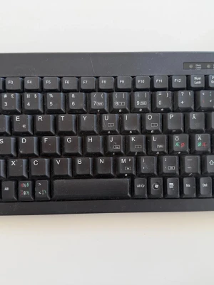 Deltaco TB-5V Minitangentbord – Nordisk Layout – Kompakt & Smidigt - Säljer ett Deltaco TB-5V minitangentbord i mycket bra skick. Ett kompakt och smidigt tangentbord med 89 tangenter och nordisk layout – perfekt för mindre arbetsytor, hemmakontor eller som extratangentbord.  Tangentbordets mindre format gör det enkelt att ta med sig samtidigt som det erbjuder en bekväm skrivupplevelse.  Specifikationer: • Modell: Deltaco TB-5V • 89 tangenter • Nordisk layout • Kompakt och platsbesparande design • Perfekt för kontor, hem eller resor   Kan hämtas i Malmö/Klagshamn 