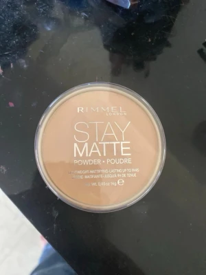 Rimmel Stay Matte puder foundation - Rimmel Stay Matte är ett kompakt puder i en beige nyans som ger en matt finish. Puderet kommer i en rund plastförpackning med genomskinligt lock och har ett snyggt mönster pressat i pudret. Perfekt för att hålla huden fräsch och glansfri hela dagen.