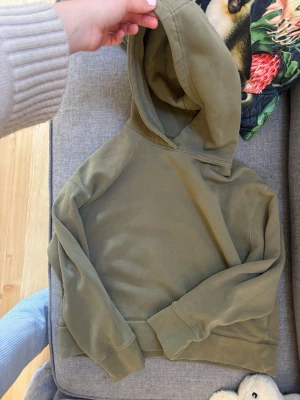 Olivgrön hoodie från Zara - Snygg olivgrön hoodie från Zara med klassisk passform och mjukt material. Hoodien har en stor huva och ribbade muddar vid ärmslut och nederkant. Perfekt för en avslappnad och trendig look.