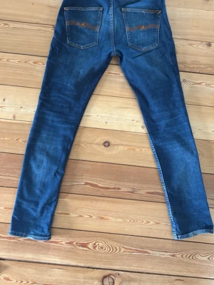 Blå skinny jeans med slitningar - Nudie jeans i modellen Grim Tim och storlek W31 L32. Jeansen är i bra skick och har inga defekter. Proset är ej hugget i sten.