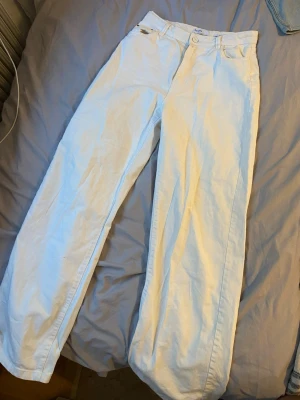 Vita wide leg jeans från Bershka - Säljer ett par vita wide leg jeans från Bershka. De har hög midja, raka och vida ben samt klassisk femficksdesign. Perfekta för en avslappnad och trendig look. Materialet är denim i bomullskvalitet.
