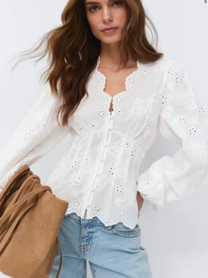 Vit broderad blus med puffärm - Romantisk vit blus från Gina Tricot med broderade blommor, figurnära passform och knappar framtill. Blusen har långa puffärmar och vågig kant vid halsringning och nederkant. Perfekt till jeans eller kjol för en trendig look.