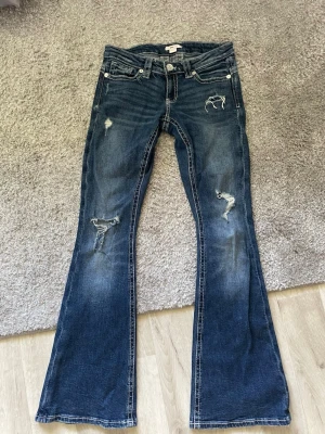 Lowwaist bootcut jeans - Snygga blå bootcut jeans med hål. Dem är köpta på Gina, inte använda mycket då dem inte passar. Strl S i 14+ 