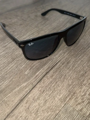 Rayban boyfriend  - Klassiska mörkblå Wayfarer solglasögon från Ray-Ban med mörkablå glas och ikonisk logga på bågen. Snygg och tidlös design som passar till alla outfits. Bågarna är i plast och har silverfärgade detaljer vid fronten.