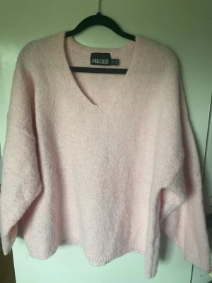 Oversized stickad rosa tröja - Köpt från Nelly. Kan bäras som off the shoulder. Oversized. Börjar bli lite noppig.