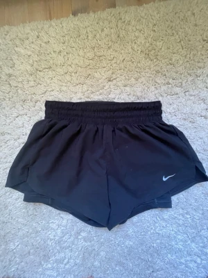 Nike joggingshorts dam - Säljer dessa Nike joggingshorts i strl XS. Det är cykelbyxor under första lagret och de har två små fickor för t.ex. nycklar. De är i gott skick men har tre fläckar (sista bilden) som jag säkert tror går bort i tvättmaskinen men annars är det inga synliga defekter på dem. Säljer pga att de är för små för mig.