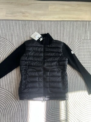 Svart dunväst från Moncler - Snygg svart dunväst från Moncler med quiltad front och två dragkedjeförsedda fickor. Rimliga prisförslag tack och pris kan diskuteras vid snabbköp. Nfc finns 
