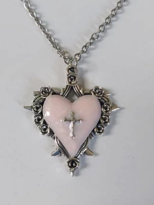 Halsband hjärta kors - Silvrigt halsband hjärta med rosa emalj legering kors i mitten  rosor och taggar runt om fina detaljer. Materialet rostfritt stål 