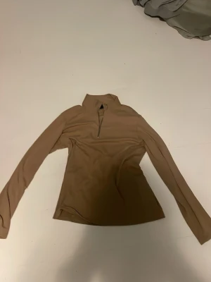 Beige långärmad tröja Selected Homme - Snygg beige långärmad tröja från Selected Homme med halv dragkedja vid halsen. Tillverkad av ekologiska fibrer och har en smal passform. Perfekt för lager på lager och enkel att matcha med olika outfits. Vet ej storlek. passar för en som är runt 178 o neråt. Storlek M 