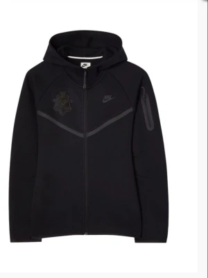 Svart Nike AIK hoodie med dragkedja - Svart hoodie köpt från AIK shopen med AIK-logga på bröstet och A.I.K.-text på ryggen. Hel dragkedja framtill, luva. Tillverkad i mjukt material som passar perfekt för en sportig och stilren look.  Säljes för att den inte kommer till användning längre💕                                             Nypris 1599