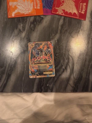 Pokémonkort Mega Charizard EX - Säljer ett Pokémonkort med motivet Mega Charizard EX. Kortet har färgstarka illustrationer i blått, orange och svart med japansk text och holografiska detaljer. Perfekt för samlare eller Pokémon-fans som vill utöka sin kortsamling., detta kortet är jätte sällsynt och finns ingenstans att köpa längre.