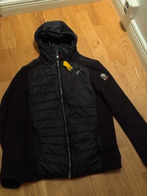 Svart pufferjacka från Parajumpers - Parajumpers cardigan, strl M passar även S Mycket fint skick och sparsamt använd. Inga hål, fläckar eller skador. Bekväm och stilren, perfekt för sommaren och svala kvällar. Säljs eftersom den inte används.
