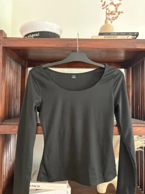 Svart långärmad topp  - En enkel och stilren svart långärmad topp med rund halsringning. Tillverkad i mjuk bomull med en normal passform som passar perfekt till alla dina outfits.