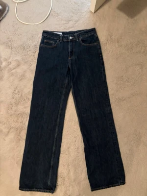 Mörkblå raka jeans - Säljer ett par mörkblå jeans med rak passform. Jeansen har en klassisk femficksdesign och är tillverkade i ett kraftigare denimtyg. Perfekta för en avslappnad och stilren look.