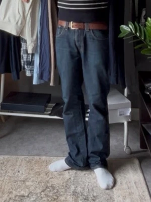 Raw Nudie Jeans - Nudie Jeans i modellen Slim Jim Dry Broken Twill. Modellen är en slim bootcut modell. Jeansen är 100% cotton och kommer med det fortsätta att få fades med användning. Modellen på bilderna är 178 och väger cirka 60kg. Mått: Hela plagget:101cm, midja:41cm och benöppning 21cm