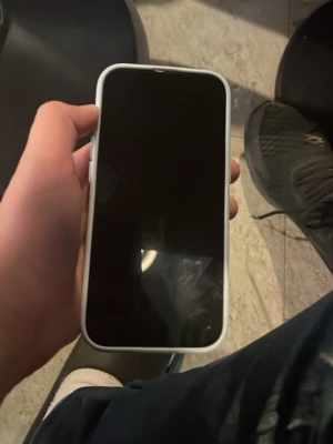 Vit iPhone med pop it-skal - Säljer en iPhone med ett vitt pop it-skal. Telefonen har rundade hörn och två kameror på baksidan. Skalet är gjort av mjukt material och har en pop it-yta som är perfekt att pilla på. Klassisk Apple-design och modern look.