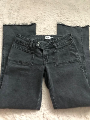 Svarta jeans med rå kant från 157 - Säljer ett par svarta jeans från 157 med raka ben och råa, fransiga benslut. Jeansen har stora fickor fram och klassiska bakfickor. Materialet är mjukt denim som ger en avslappnad look. Perfekta för dig som gillar en trendig och enkel stil.