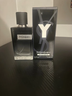 Yves Saint Laurent Y Eau de Parfum 100ml - Yves Saint Laurent Y Eau de Parfum i 100ml flaska. Parfymen kommer i en elegant, svart glasflaska med metallisk etikett och svart lock. Förpackningen är svart med en stor silverfärgad Y-logga. En modern och stilren doft för dig som gillar exklusiva parfymer.