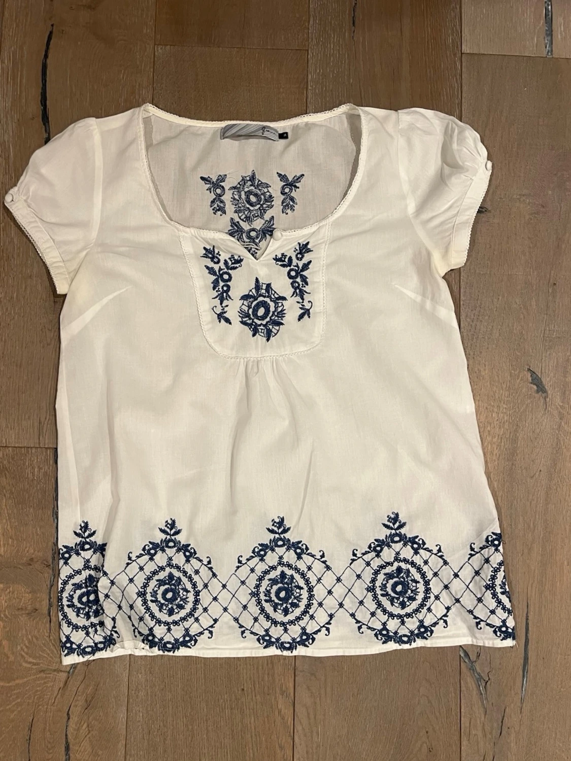 Vit blus med blå broderier