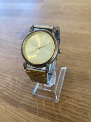 Vintage Citizen Gold Quartz Guldfärgad - Citizens (armband) Quartz herrklocka med en guldfärgad urtavla och tydliga arabiska siffror vid 12, 3, 6 och 9. Klockan har ett quartz-urverk och en stållänk. Boetten är i en guldfärgad ton med viss patina. Länken är i rostfritt stål med ett viklås. Skick enligt bilder. Behöver nytt batteri.  Begagnat värde: < 500 SEK Mitt pris: 289 SEK  Skickas alltid snabbt och spårbart. Skriv vid frågor och se gärna mina andra annonser!   GRATIS: För återkommande kunder erbjuder jag personlig experthjälp för 