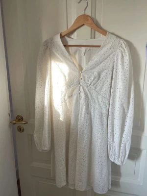 Vit klänning  - Söt vit klänning med broderi, puffiga armar och söta knappar . Perfekt till sommarens stunder som student, midsommar eller andra event.  