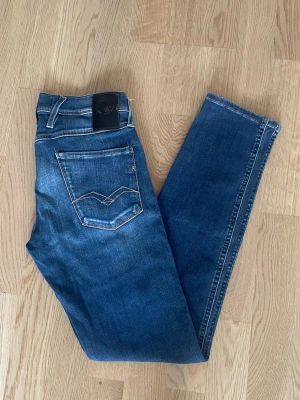 Blå Replay Anbass jeans W28 L32 - Jag säljer dom här riktigt snygga Replay Anbass jeansen i storlek W28 L32. De är i fint skick. Tveka inte att höra av er!                                      Mått: Längd=98cm. Midja=37cm