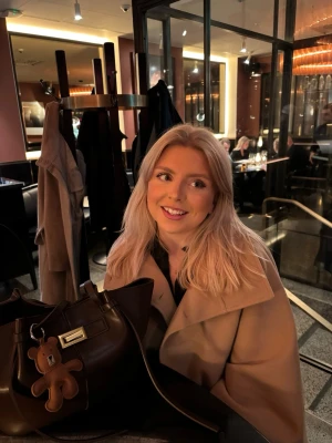 Beige cape-kappa med knytband - Säljer en stilren beige cape-kappa från Gina Tricot med hög krage och dubbla knappar. Kappan har vida ärmar och ett knytband i midjan som ger en snygg siluett. Materialet är mjukt och känns lyxigt, perfekt för att lyfta din outfit under kyliga dagar.
