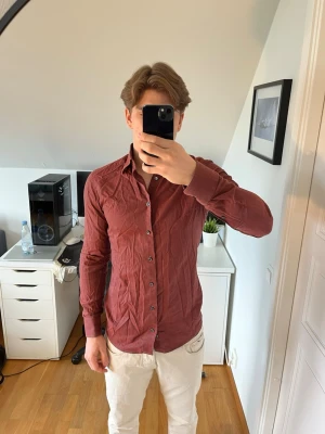 Röd skjorta från Eton - Snygg röd skjorta från Eton med klassisk krage och knappar framtill. Den är tillverkad i mjuk bomull. Hör gärna av dig vid frågor!