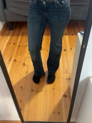 Blå lowaisted jeans från Nelly  - Säljer ett par blå lowaisted bootcut jeans utan midja. Storlek 38. Jag är 173 cm lång och dessa jeans är korta på mig! 
