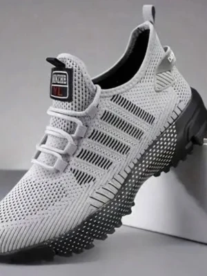 Grå stickad sneaker med svart sula - Snygg grå sneaker från XINZHE med stickad ovandel och ventilerande mesh. Skon har svarta detaljer på sulan och en unik, grovt mönstrad yttersula för extra grepp. Elastisk snörning och dragflik bak för enkel påtagning. Perfekt för en sportig och modern stil.