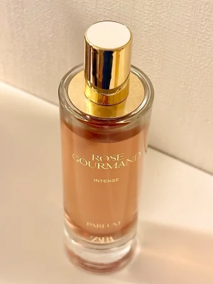 Zara Rose Gourmand Intense 80 ml - Zara Rose Gourmand Intense, 80 ml. Går inte att få tag på längre då detta var en limited edition. Knappt använd, vilket syns på bild. Kommer i originalförpackningen. Givetvis förvarad mörkt, torrt och svalt. Toppnoter: Päron, rom, ros. Hjärtnoter: Jasmin, karamell, saffran, amber.  Basnoter: Vanilj 