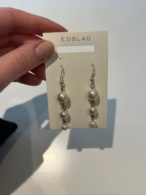 Hängande pärlörhängen - Snygga hängande örhängen med tre vita pärlor i olika storlekar på varje örhänge. Krokar i silverfärgad metall och stilren design som ger en elegant touch till din look. I använt skick därav priset!🥰