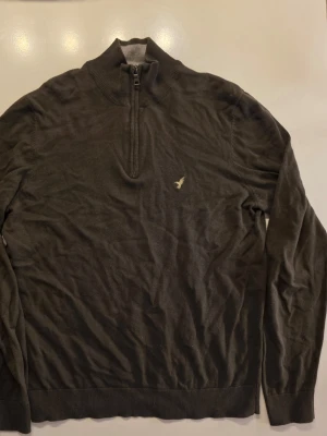 Mörkgrön half zip-tröja - Mörkgrön tröja med halv dragkedja och ribbad krage. Tröjan har långa ärmar och ribbade muddar vid ärmslut och nederkant. Perfekt för lager på lager och en clean look         Bröstmått: ca 52.5 cm  Armlängd: 50 cm          Hela: 69 cm