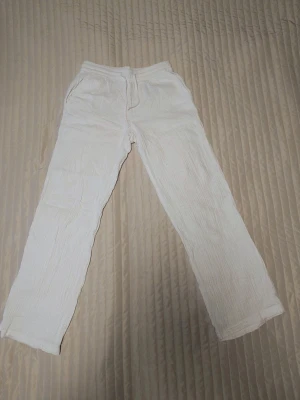 Vita linnebyxor från JDY - Säljer ett par vita linnebyxor från JDY med rak passform och resår i midjan. Byxorna har en avslappnad look och är tillverkade i ett luftigt linnematerial som passar perfekt till sommaren. Superenkla att matcha med olika toppar och sneakers.
