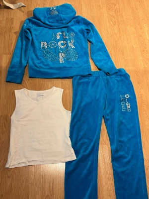 Y2K vintage blå tracksuit  - Blå tracksuit från 2000-talet med glitter detaljer och tjockare material, byxorna är lågmidjade. Alla glitter kristaller sitter på plats och allt är i super bra skick!💕 Linnet ingår också. Den är tyvärr för liten för mig!