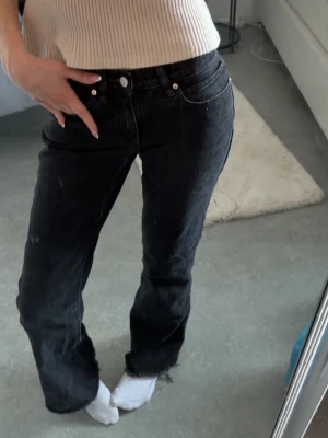 Abrand Jenas  - Svarta lågmidjade bootcutjeans ifrån Abrand med slitningar längst ner! Strl 23. (Jag är 169cm för referens) 