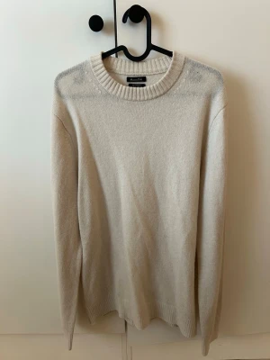 Beige stickad tröja Massimo Dutti - Beige stickad tröja från Massimo Dutti med rund halsringning och ribbade muddar vid ärmslut och nederkant.