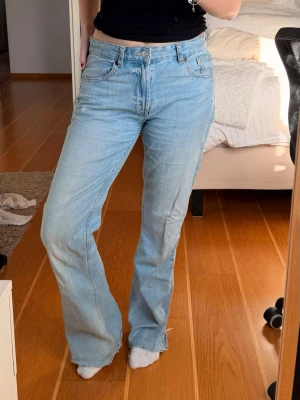 Ljusblå raka jeans midwaist - Säljer ett par ljusblå jeans med rak passform och medelhög midja. Avklippta längst ner så passar någon som är 155-165 beroende på hur man vill att de sitter i längden, jag är ungefär 158.