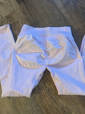 Ljusrosa seamless leggings från Relode - Säljer ett par ljusrosa seamless leggings från Relode med hög midja och scrunch-detalj bak. Materialet är stretchigt och följsamt, perfekt för träning eller chill. Diskret logga framtill i midjan och långa ben. Storlek m passar även s, använd max 3 gånger