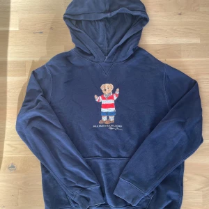 Mörkblå hoodie Polo Bear Ralph Lauren - Säljer en riktigt schyst hoodie från ralphlauren. Den är i storlek XL 18-20 år men sitter som L i vanlig storlek. Jätte fint skick och riktigt snygg. 