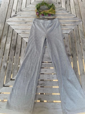 Grå ribbade bootcut leggings - jag säljer ett par grå ribbade bootcut leggings. de är stretchiga, sitter skönt och har hög midja. superfina till både sneakers och boots och passar till typ allt. använda och har lite nopprar men fortfarande i bra skick och kan ge mer!!💕