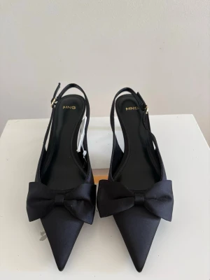 Svarta pumps med rosett  - Jättesnygga svarta klackskor från mango, storlek 37. Aldrig använda på grund av för små. Går att justera banden💓