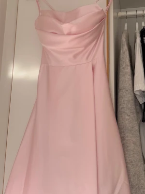 Rosa balklänning  - Säljer min älskade balklänning, den är använd under en dag. Från L&S balklännings butik i Linné. Köpt för 2500kr. Har handtvättats efter användning. Ej uppsydd. På sista bilden visas de små skavanker som uppstått under användning vilket orsakats av att den släpats i marken men ingen som syns tydligt, om klänningen läggs upp kommer inga skavanker synas. I ryggen går storleken att justera med hjälp av band. Vaddering upp till vilket fungerar som en ”inbyggd” bh. Storlek 34-36, jag bär S vanligtvis