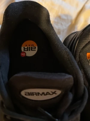 Nike Air Max svarta sneakers - Snygga svarta Nike Air Max sneakers med klassisk Air Max-logga på plösen och innersulan. Ovandelen är i mesh och syntetmaterial för bra andningsförmåga. Yttersulan har tydliga mönster och röda detaljer för extra grepp och stil. Använd en gång bara 