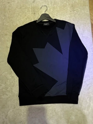 Dsquared2 Tröja - Säljer en svart tröja från Dsquared2 med en fin design på framsidan och tryck på ryggen. Storlek M inga konstigheter helt ny inga skador eller så. Perfekt till en härlig kväll en sommar som denan. Tveka ej på att höra av er!😎☀️