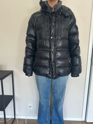Moncler jacka  - Säljer min Moncler vinter jacka!! Riktigt varm och skön. Har själv köpt den begagnad för ca 2 och ett halvt år sen!! Har bytt ena spännet på dragkedjan (se bild). Storlek 5, skulle säga att den sitter som en L.  Hör av er vid frågor! 
