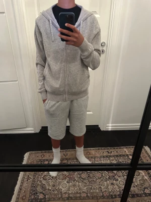 Ljusgrå Kashmir tröjafrån ONEWear - Säljer en ljusgrå kashmir tröja från ONEWear Sweden i storlek XXS. Hoodien har dragkedja framtill, huva med snören och ribbade muddar vid ärmslut och nederkant. Tillverkad i mjukt material som känns skönt mot huden. Perfekt för en avslappnad och stilren look. Själv är jag 165cm