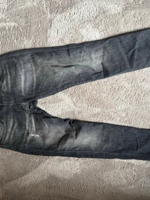 Grå slitna jeans med skinny fit - Säljer ett par grå jeans med skinny fit och slitningar på låret. Jeansen har klassisk femficksmodell, dragkedjegylf och snygga tvättade detaljer som ger en cool, använd look. Perfekta för dig som gillar streetwear och avslappnad stil. Storlek 31 waist 32 length. Jensen är i grymt skick inte så använda, Köpta för 1499 kr. Hör av dig vid intresse eller om dubbar funderingar 😀