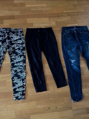 3 par Zara byxor - Säljer ett par blåa jeans ett par tygyxor med svart/vitt, detaljerat mönster över hela byxan. Slim fit-modell med normal midja och raka ben. Perfekta för dig som vill sticka ut med en unik stil. Materialet ser ut att vara en stretchig bomullsblandning. Samt ett par stretchiga svarta byxor